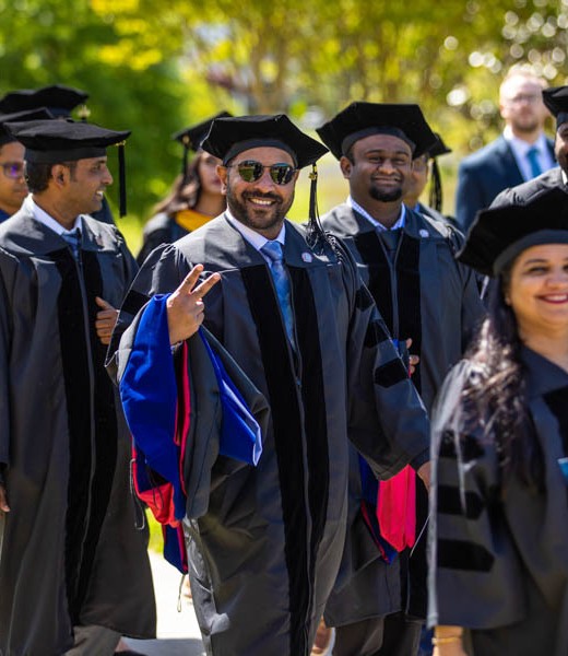 Executive students walking toward graduation ceremony