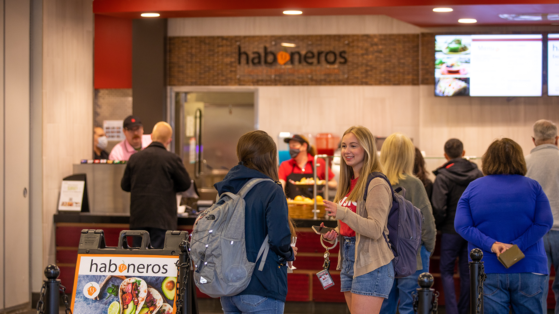 Students are waiting in line for lunch in the campus grille. 