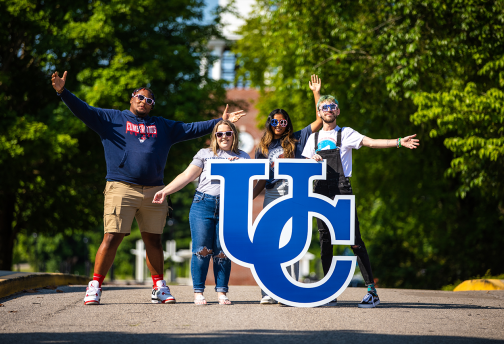 University of the Cumberlands student pose on campus with a UC sign. 