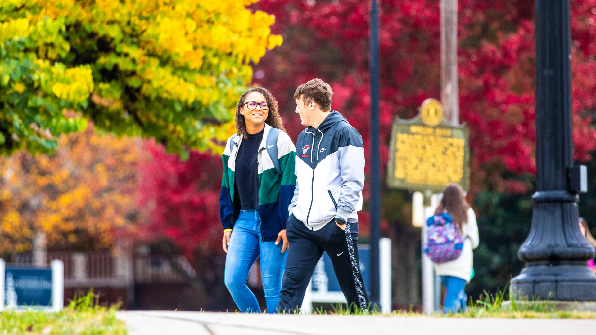 Two students walking to class during fall