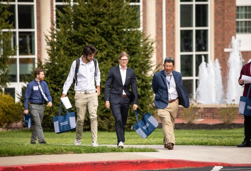 Students speak with a business professor following the annual forum. 