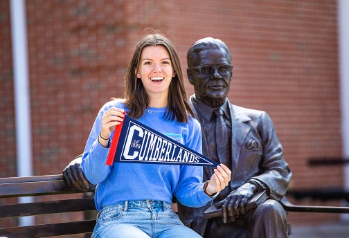 A Cumberlands alumna holds a pennant to display her school spirit. 