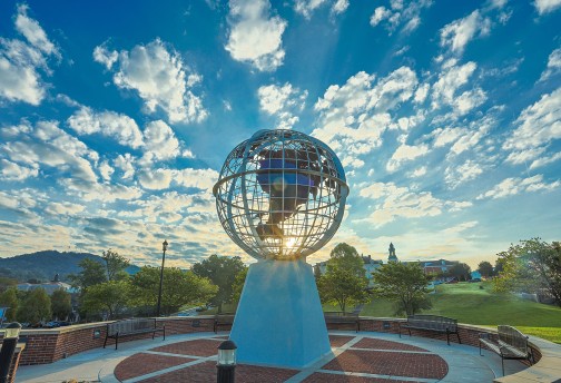 The sun rises behind the globe statue on Cumberlands' campus. 