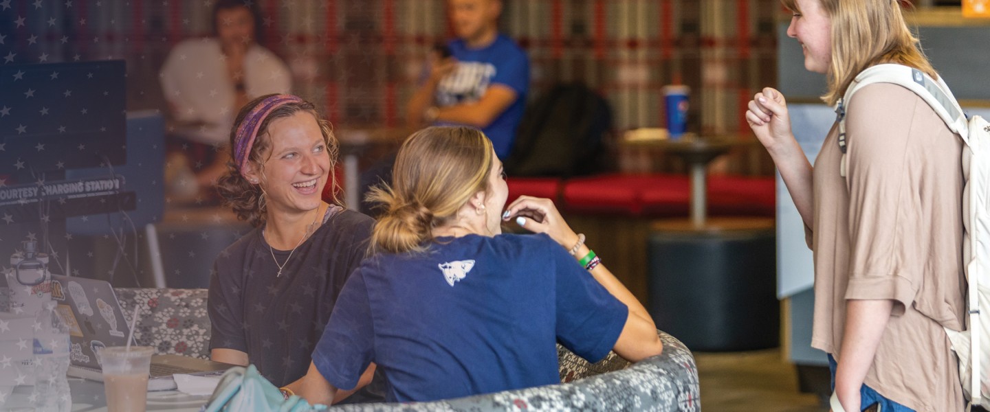 Students laugh while hanging out in the campus student center. 